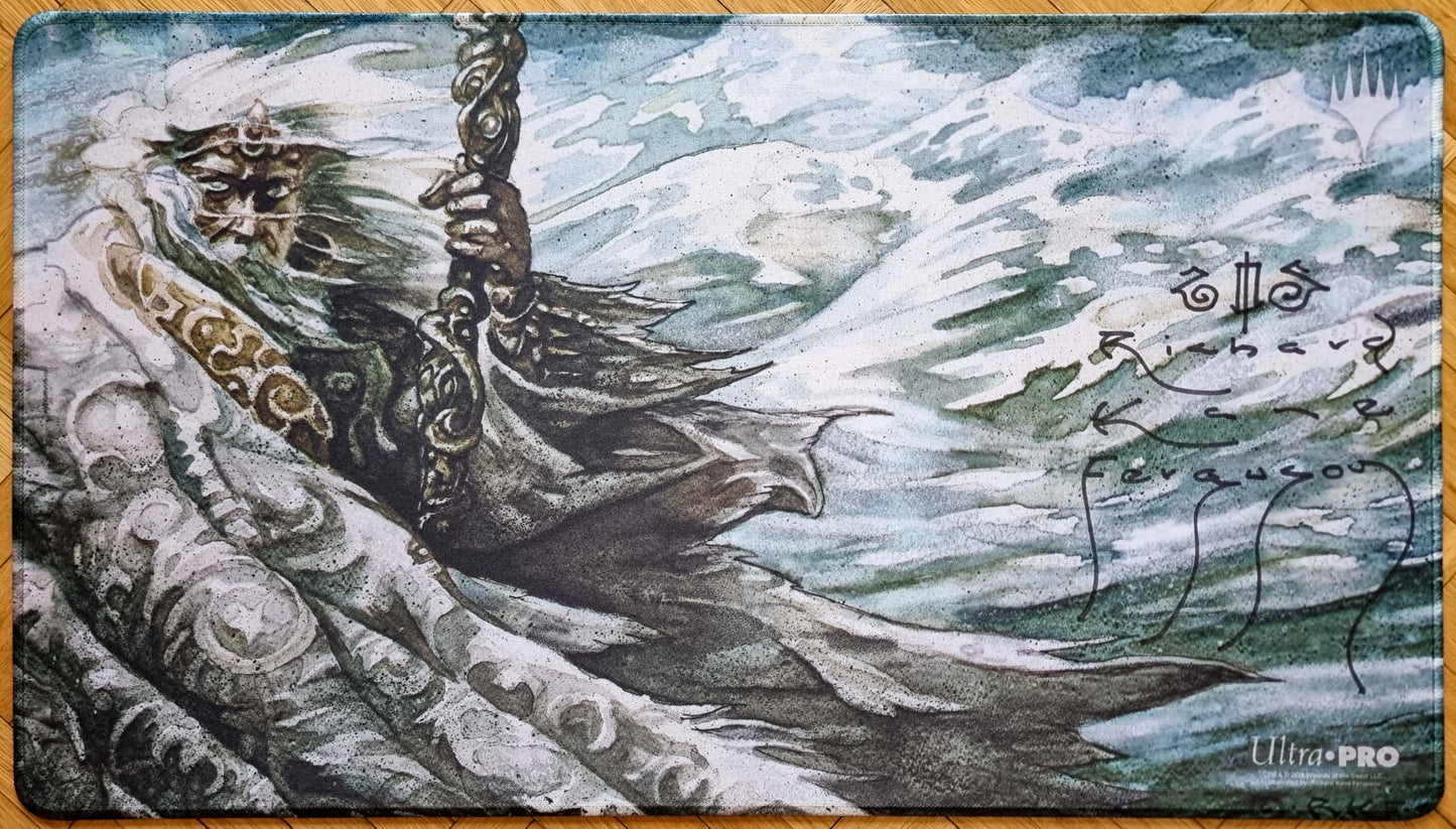 Signed Nebuchadnezzar MTG playmat featuring Richard Kane Ferguson’s Legends artwork, showing the robed figure in a windswept blue-green scene with stitched black edges.