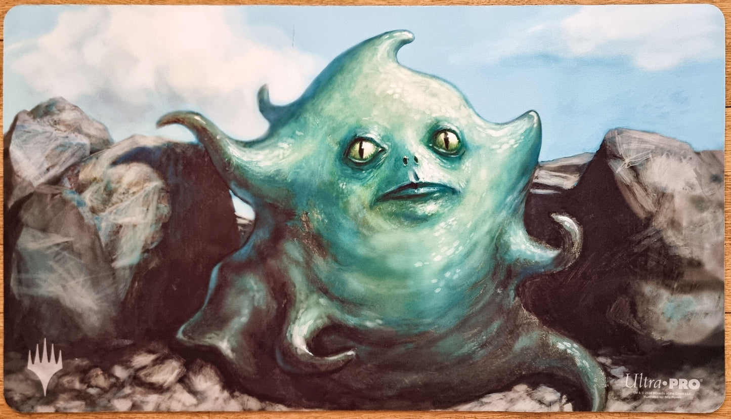 Amoeboid Changeling MTG playmat by Nils Hamm featuring a teal shapeshifter creature emerging from rocks against a pale blue sky.