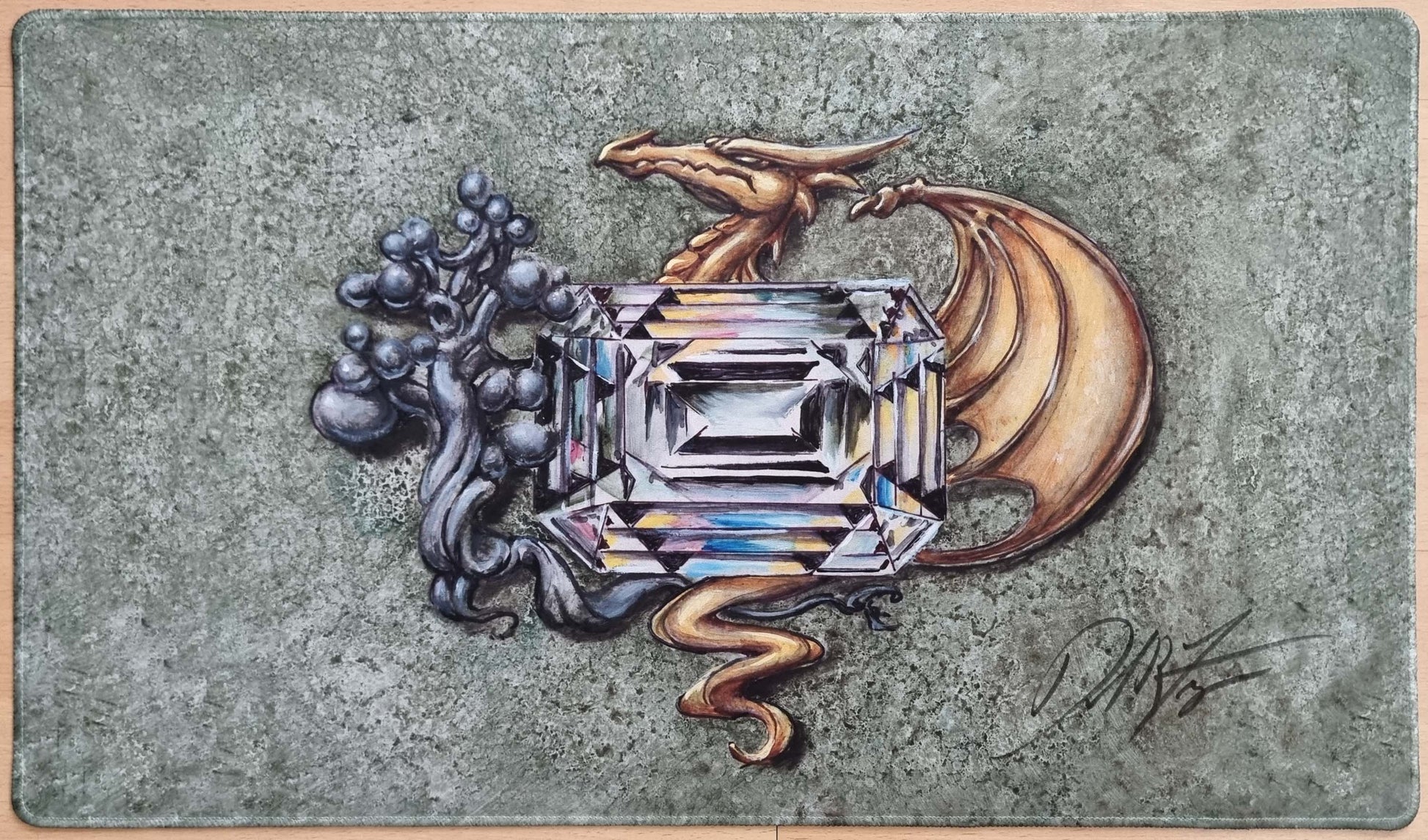 Signed stitched Earthen Mox playmat by Dan Frazier featuring a large faceted gemstone beside twisted roots and a golden dragon on a stone-textured background.