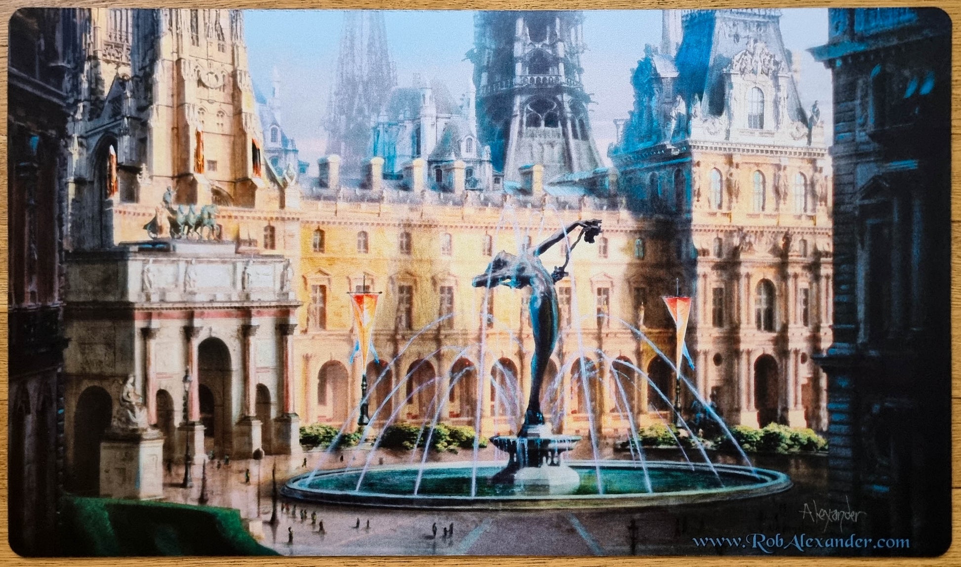 Signed Hallowed Fountain MTG playmat by Rob Alexander showing a grand fountain courtyard surrounded by ornate Ravnica-style city architecture.