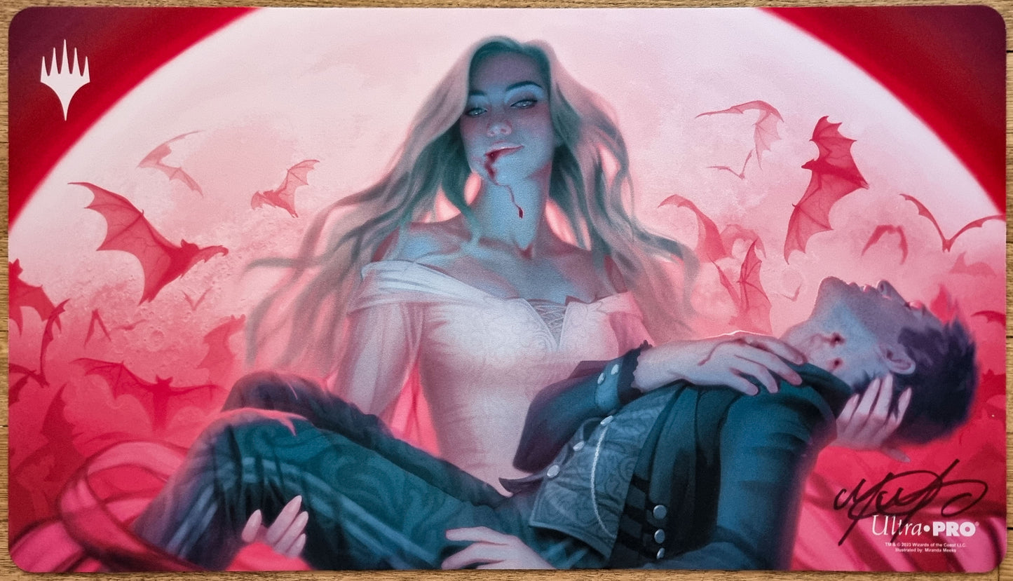 Signed Indulging Patrician MTG playmat by Miranda Meeks showing a vampire scene with red lighting, blue shadows, and bat silhouettes.