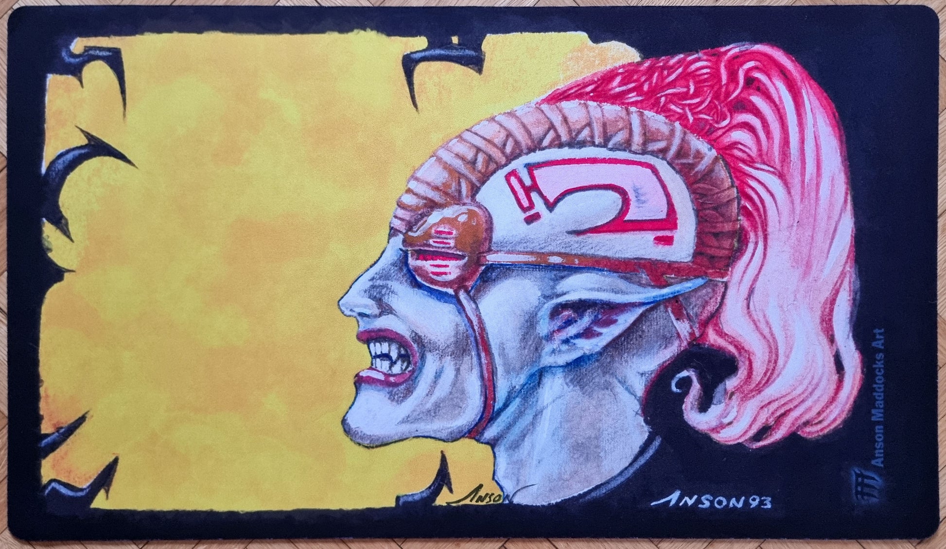 Signed Llanowar Elves playmat by Anson Maddocks featuring a dramatic side-profile portrait from Limited Edition Alpha with a yellow background and pink plume.