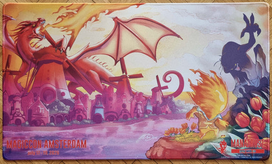 Fiery, There and Back Again ManaTrust playmat for MagicCon Amsterdam 2026, showing a flame mascot, a red dragon over a Dutch fantasy town, and stitched edges.
