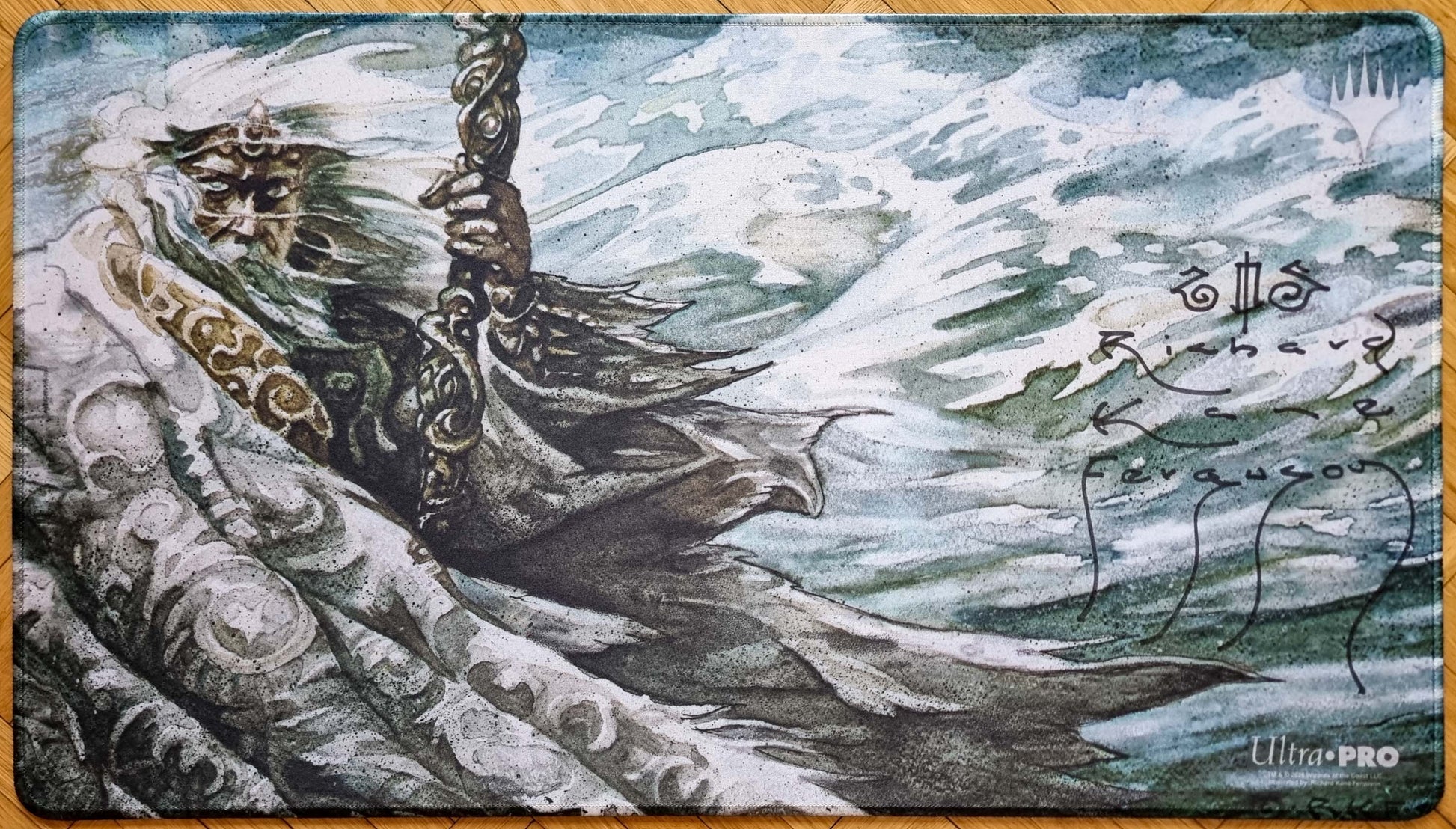 Signed Nebuchadnezzar MTG playmat featuring Richard Kane Ferguson’s Legends artwork, showing the robed figure in a windswept blue-green scene with stitched black edges.