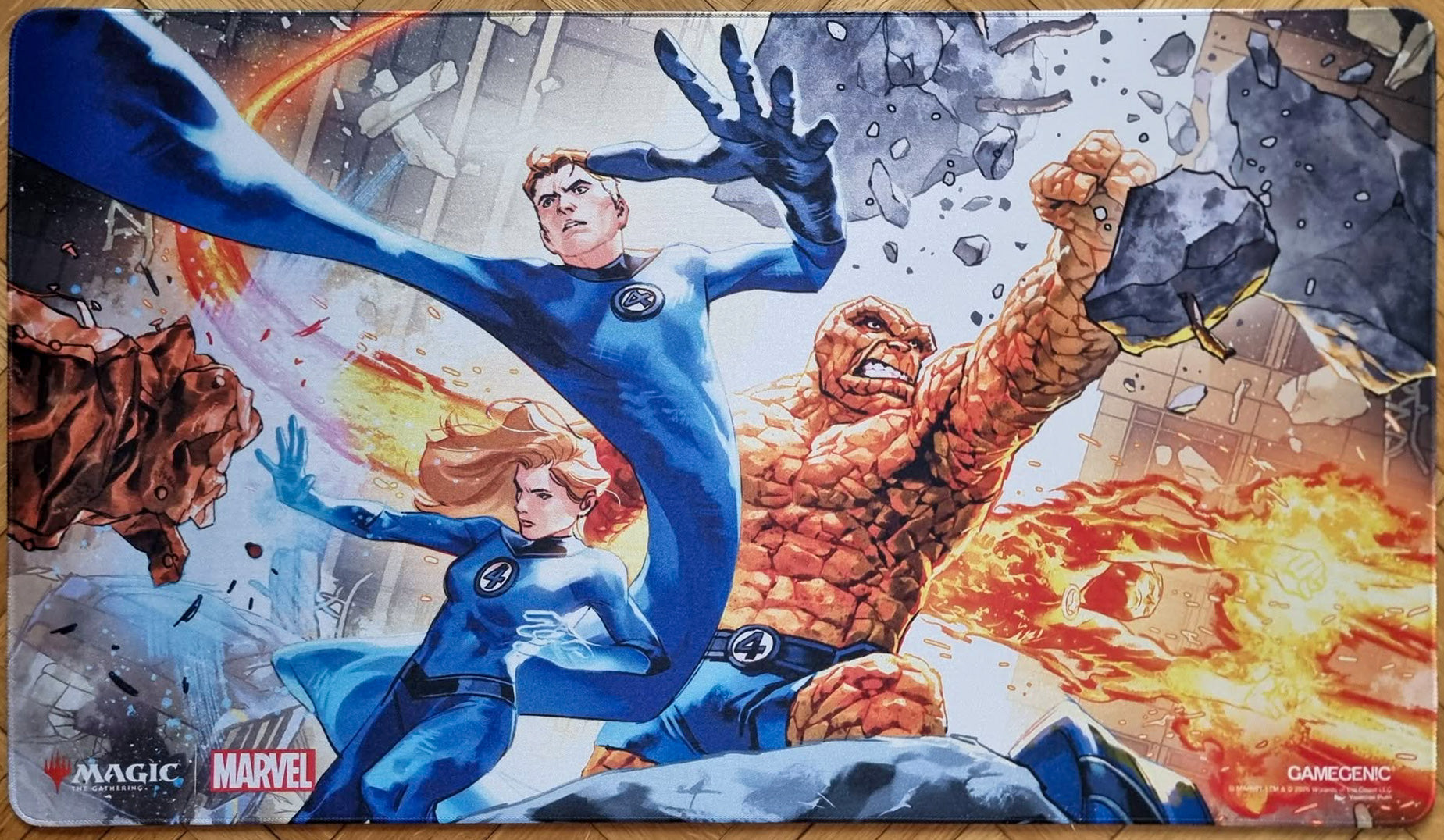 Magic: The Gathering x Marvel shiny playmat featuring Yasmine Putri’s The Fantastic Four artwork, showing Mister Fantastic, Invisible Woman, The Thing, and Human Torch in action.