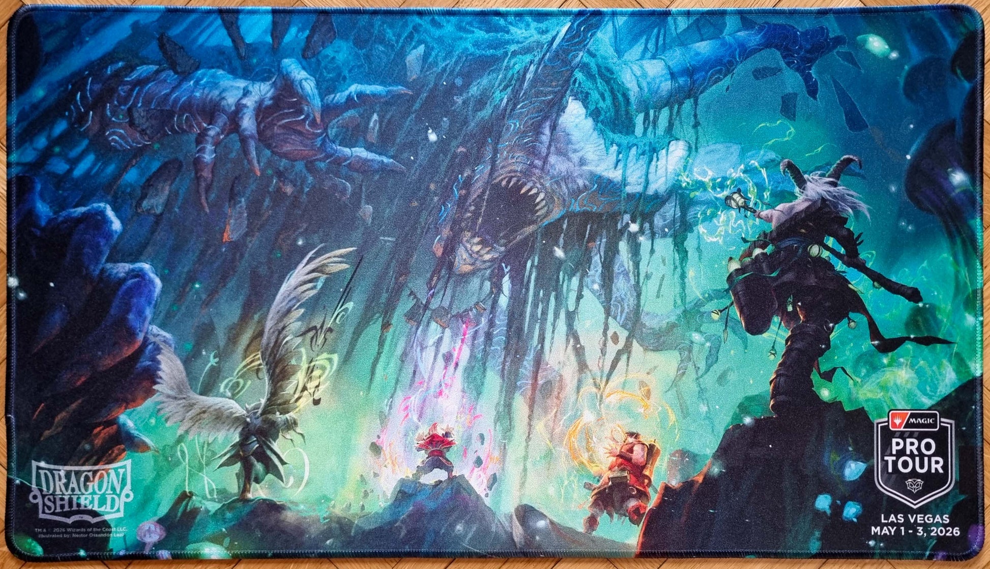 Together as One MTG playmat by Néstor Ossandón Leal for Pro Tour Las Vegas 2026, showing spellcasters facing a huge cavern monster with Dragon Shield and Pro Tour logos.